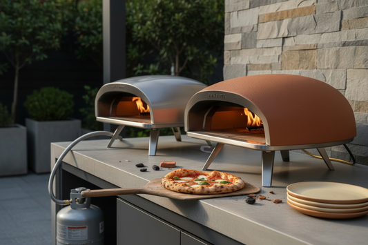 Outdoor kitchen with gas and propane pizza ovens, a wood pizza peel, and a freshly baked pizza.